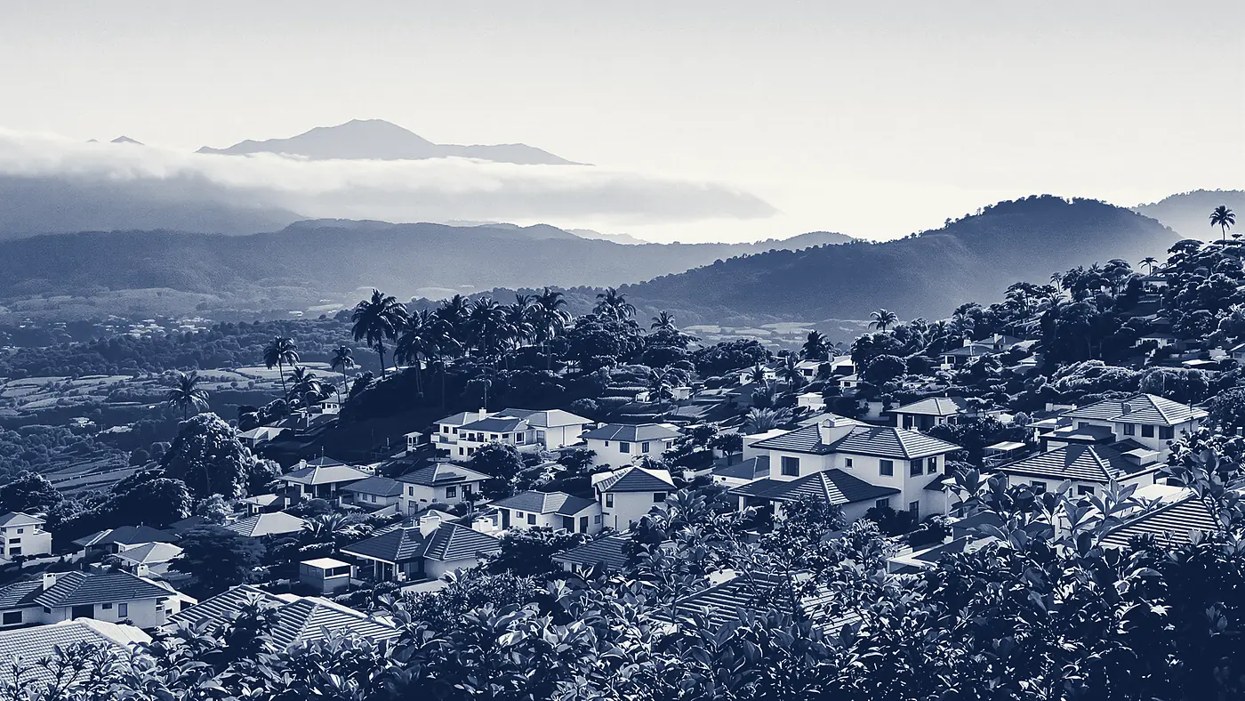 Viviendas escalonadas en una ladera del Valle Central de Costa Rica, con cordilleras y niebla al fondo, tratadas en duotono azul institucional.